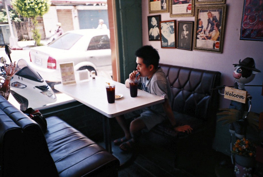 a young man sitting at a table eating a meal