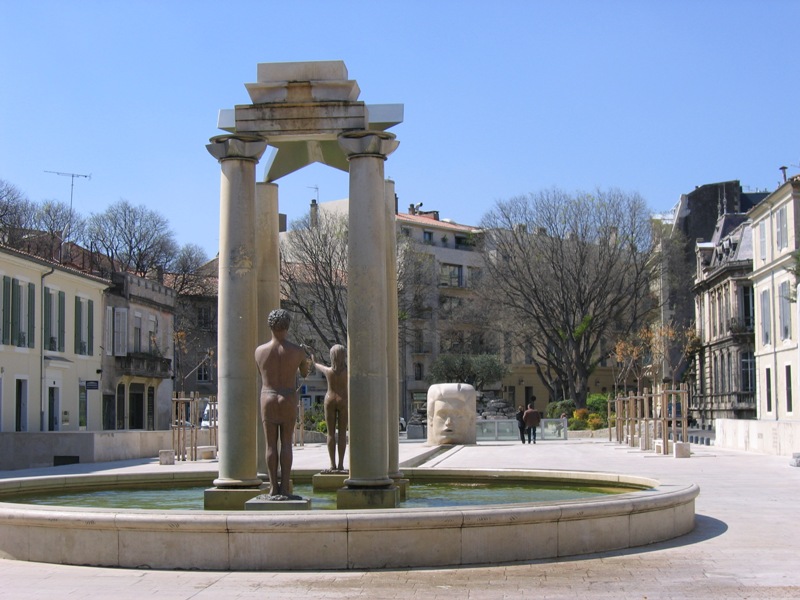 the fountain has a man statue and is surrounded by old buildings