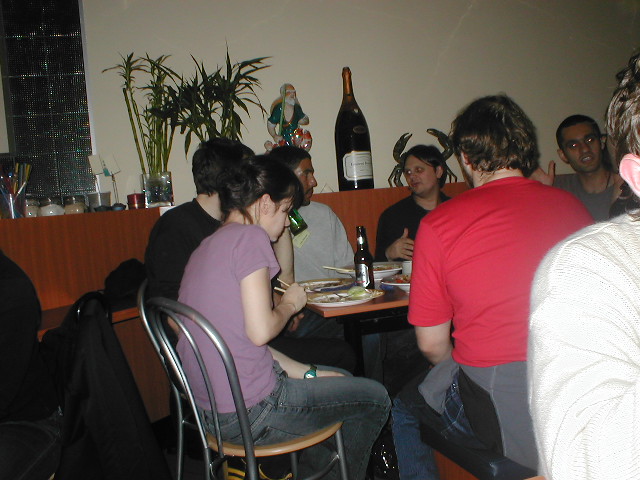 several people sit together at a table with plates and drinks
