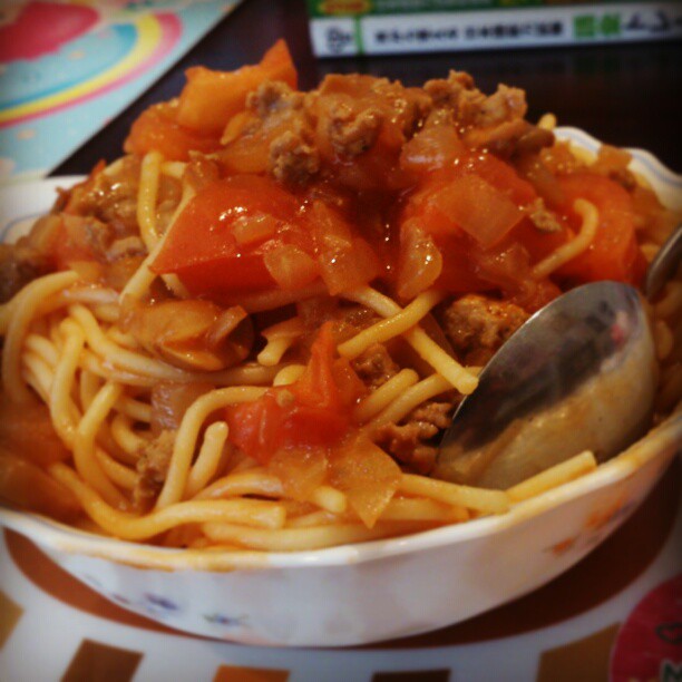 a bowl of spaghetti with meat and tomatoes in tomato sauce