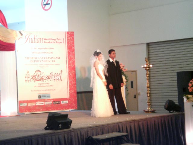 a man and woman at a wedding standing at the end of a stage