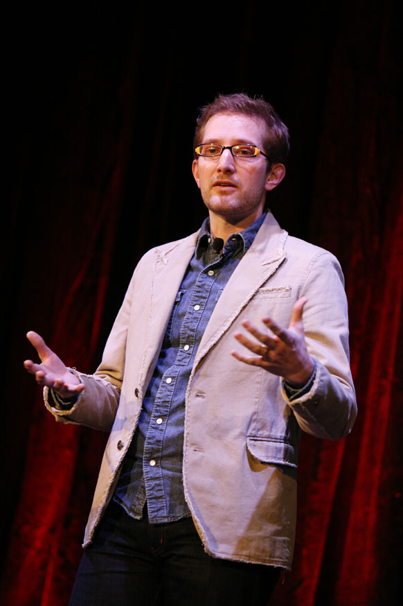 a man with glasses speaking at a ted