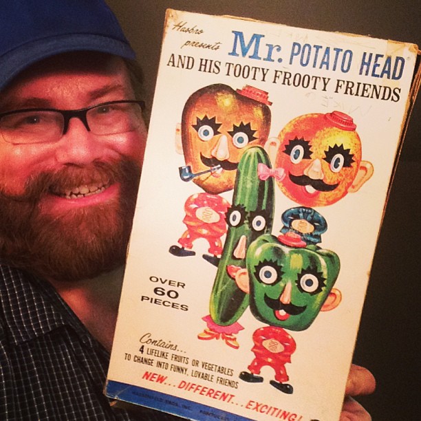 a man holds up a very old toy poster