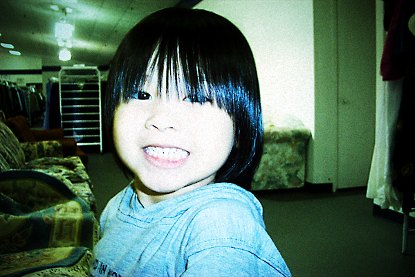a little girl with black hair smiles for the camera