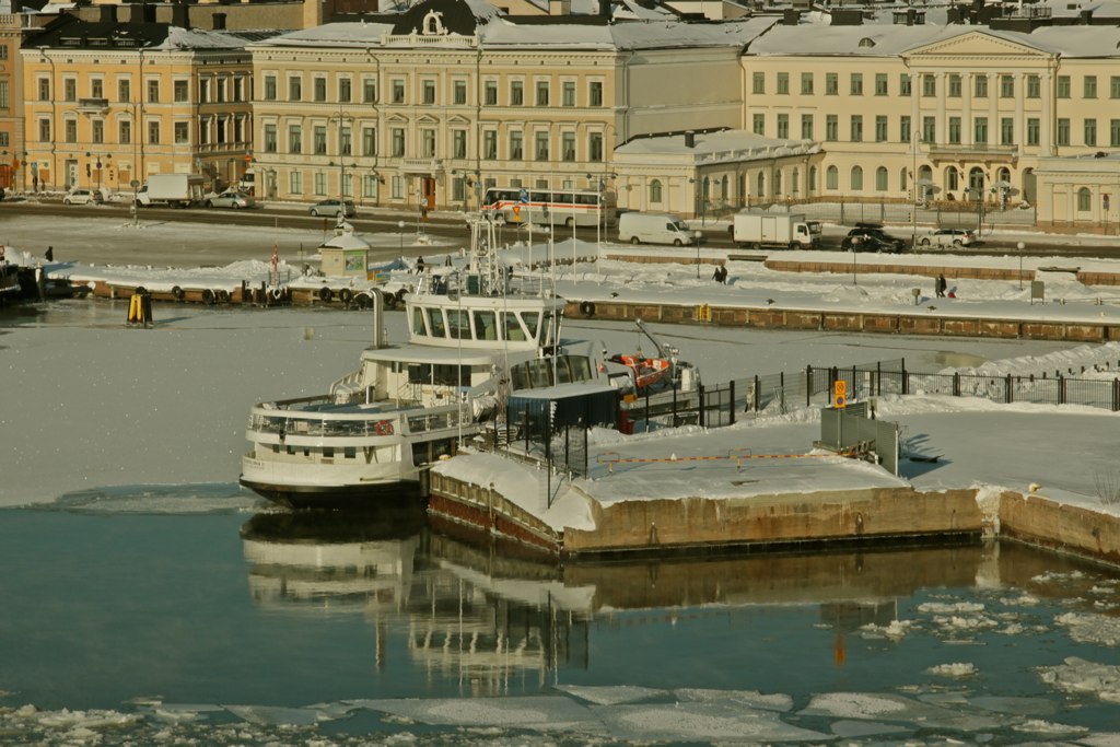 several boats are docked in the snow next to buildings