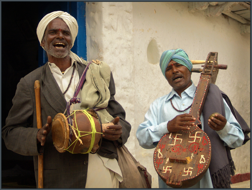 three people with instruments outside, with one on the phone