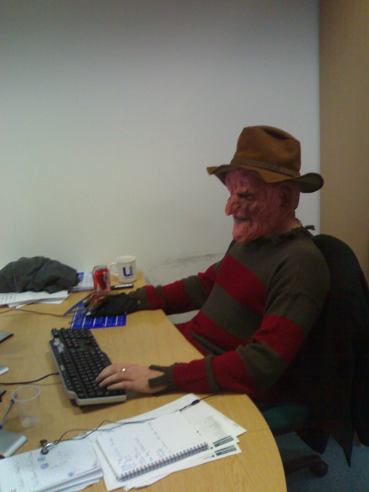 a man in a hat is at a desk using a computer