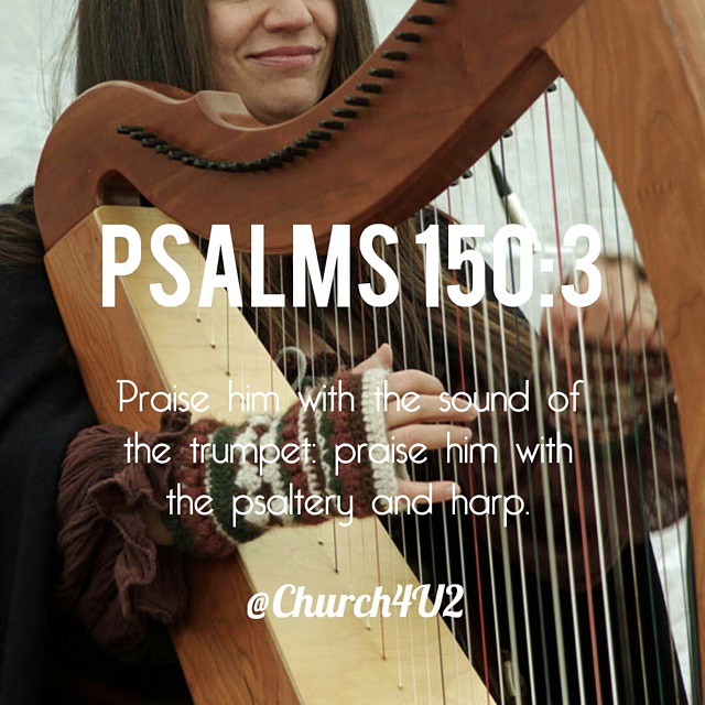 a lady holding a harp and smiling for the camera