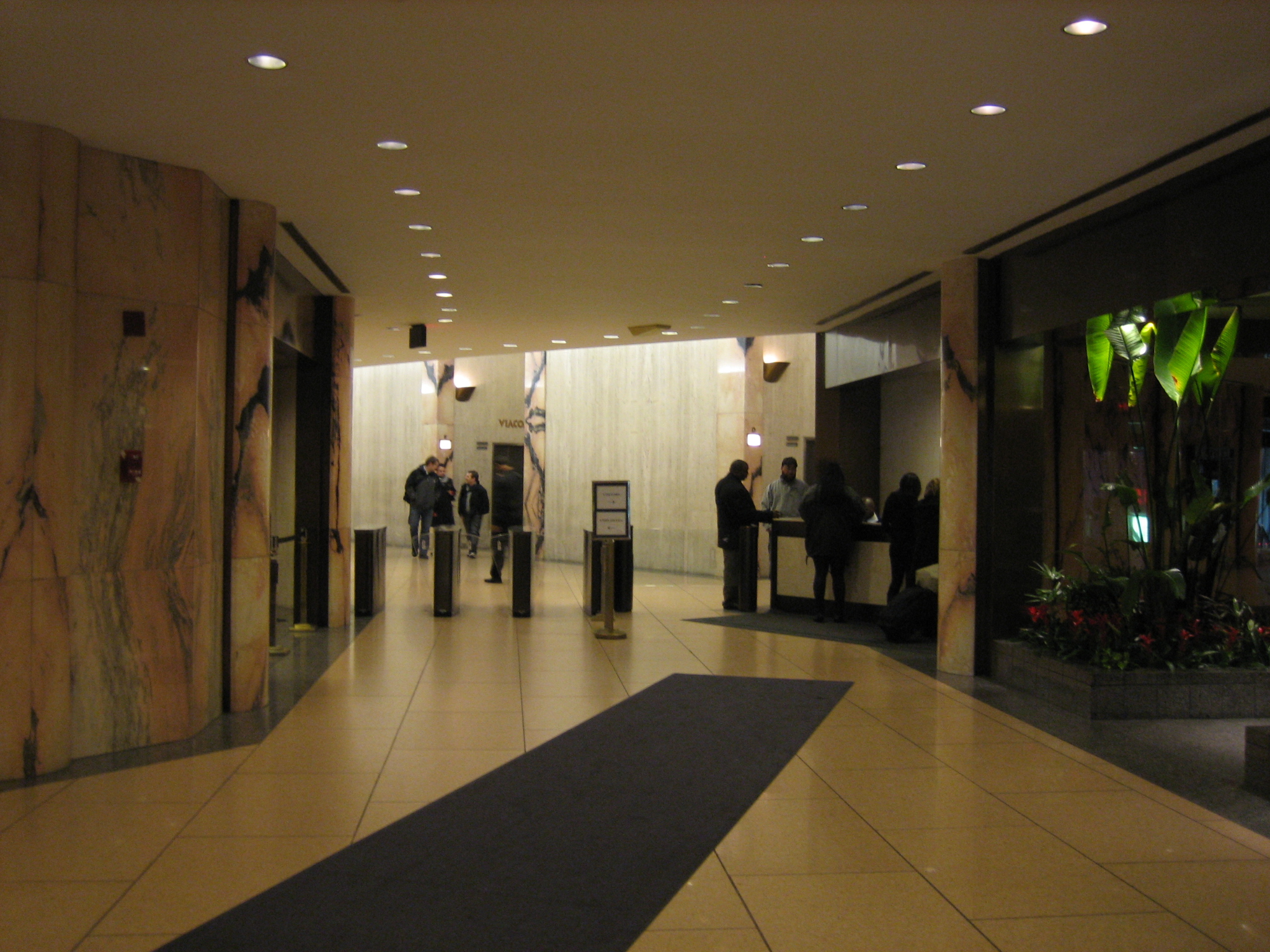 several people standing in the elevator in front of a lobby