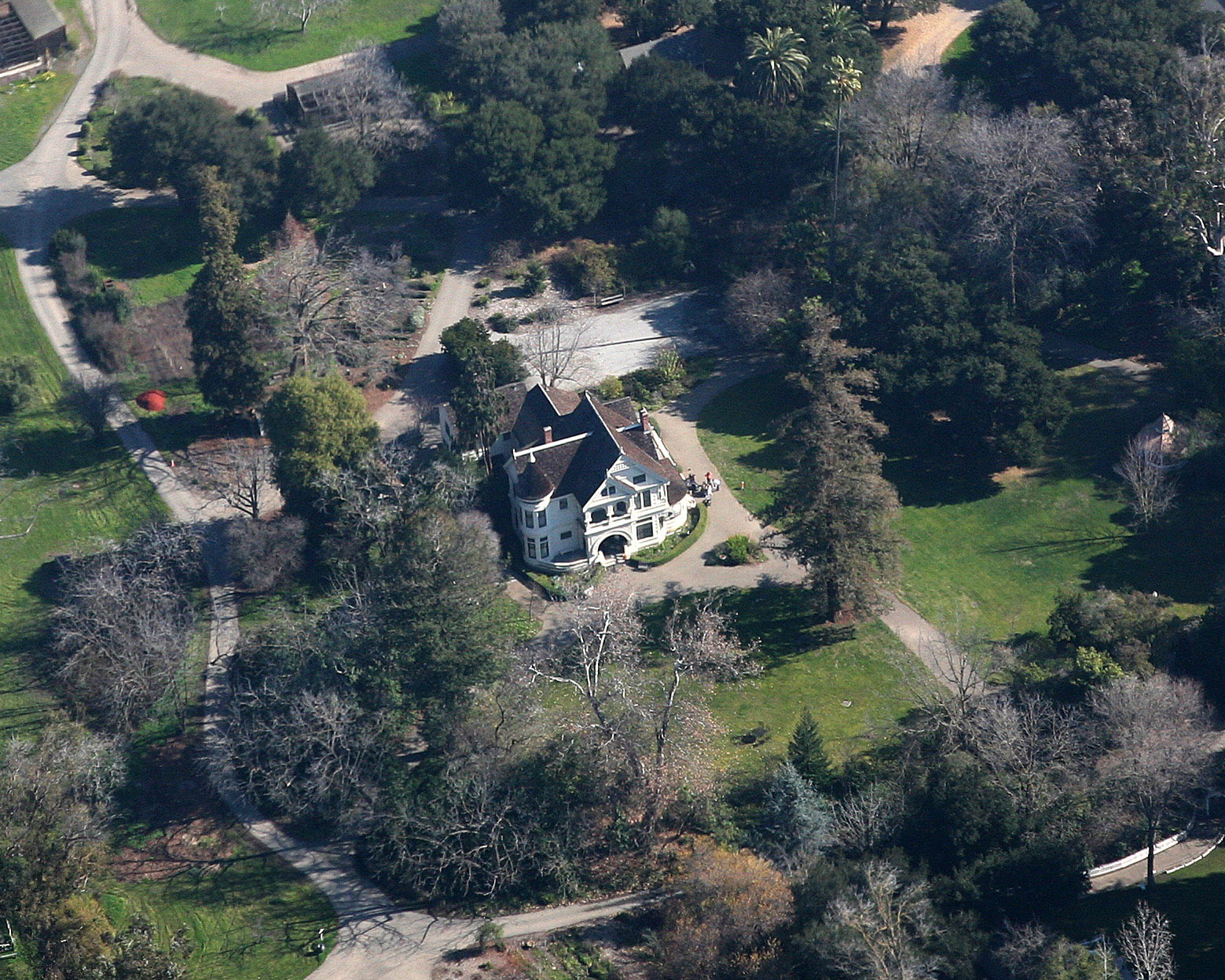 an aerial view of a mansion and surrounding trees