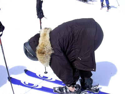 a woman bending down in skis on the snow