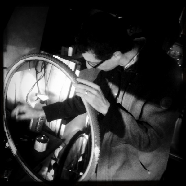 a man is looking at the reflection in his bike wheel