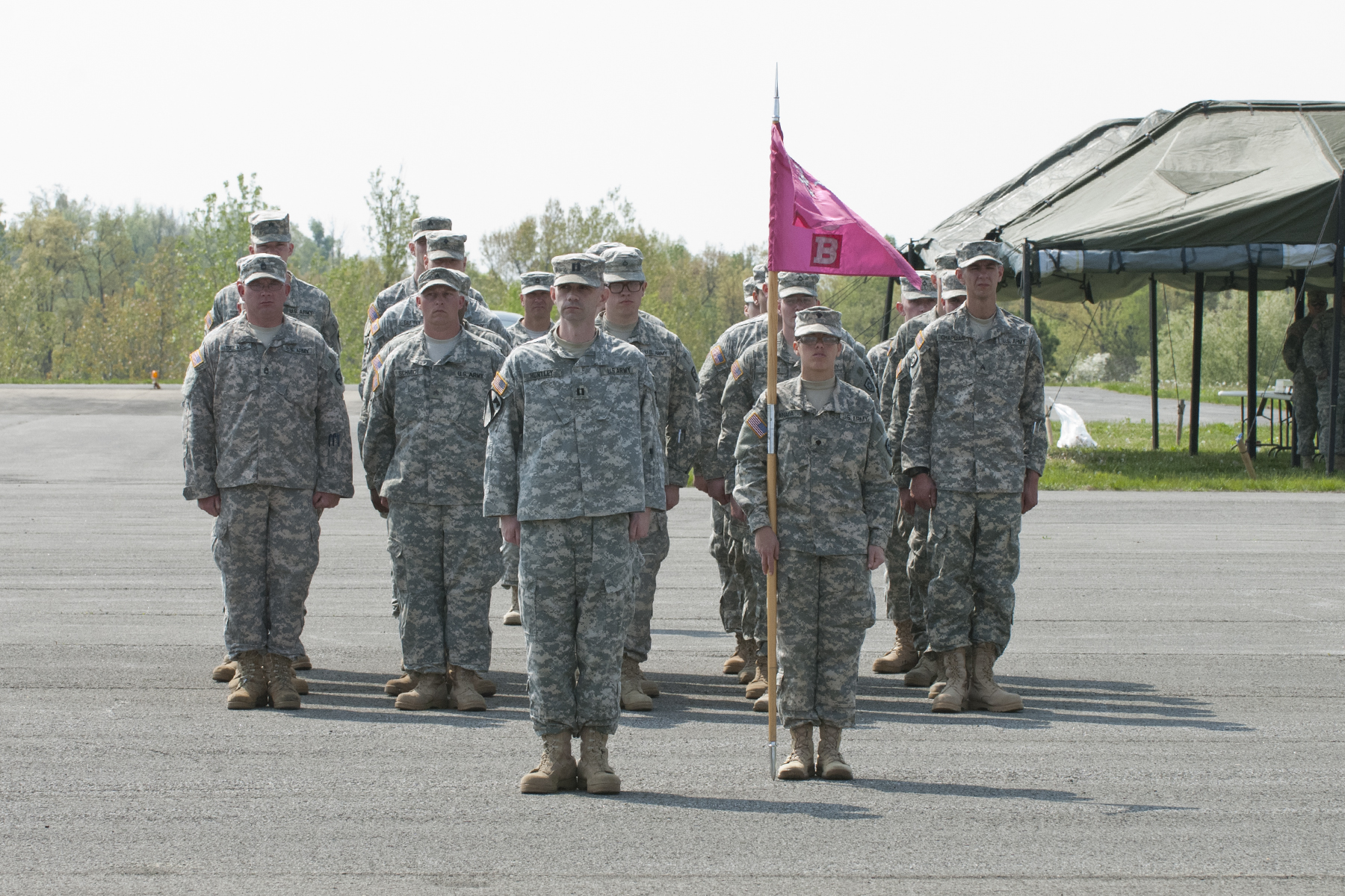 the military men in camo are holding the pink flag