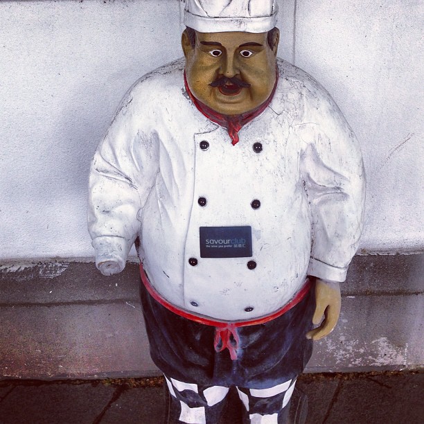 a statue of a chef next to a wall