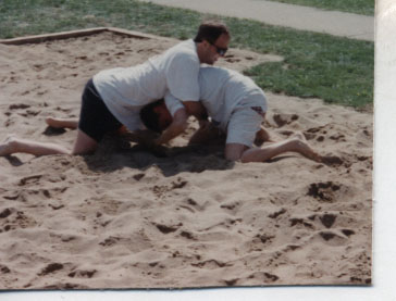 two men who are bending in the sand