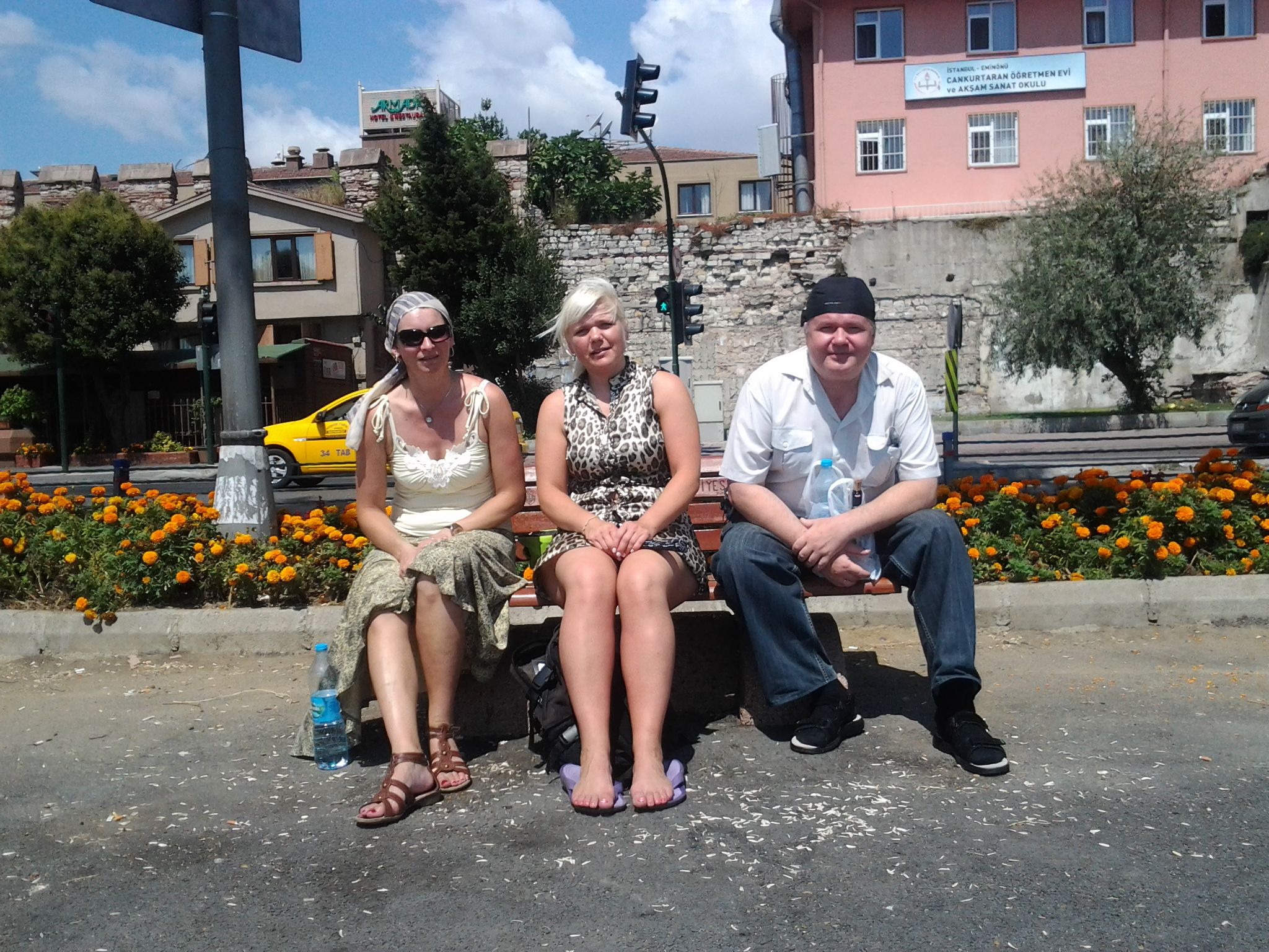 three people are sitting on a park bench