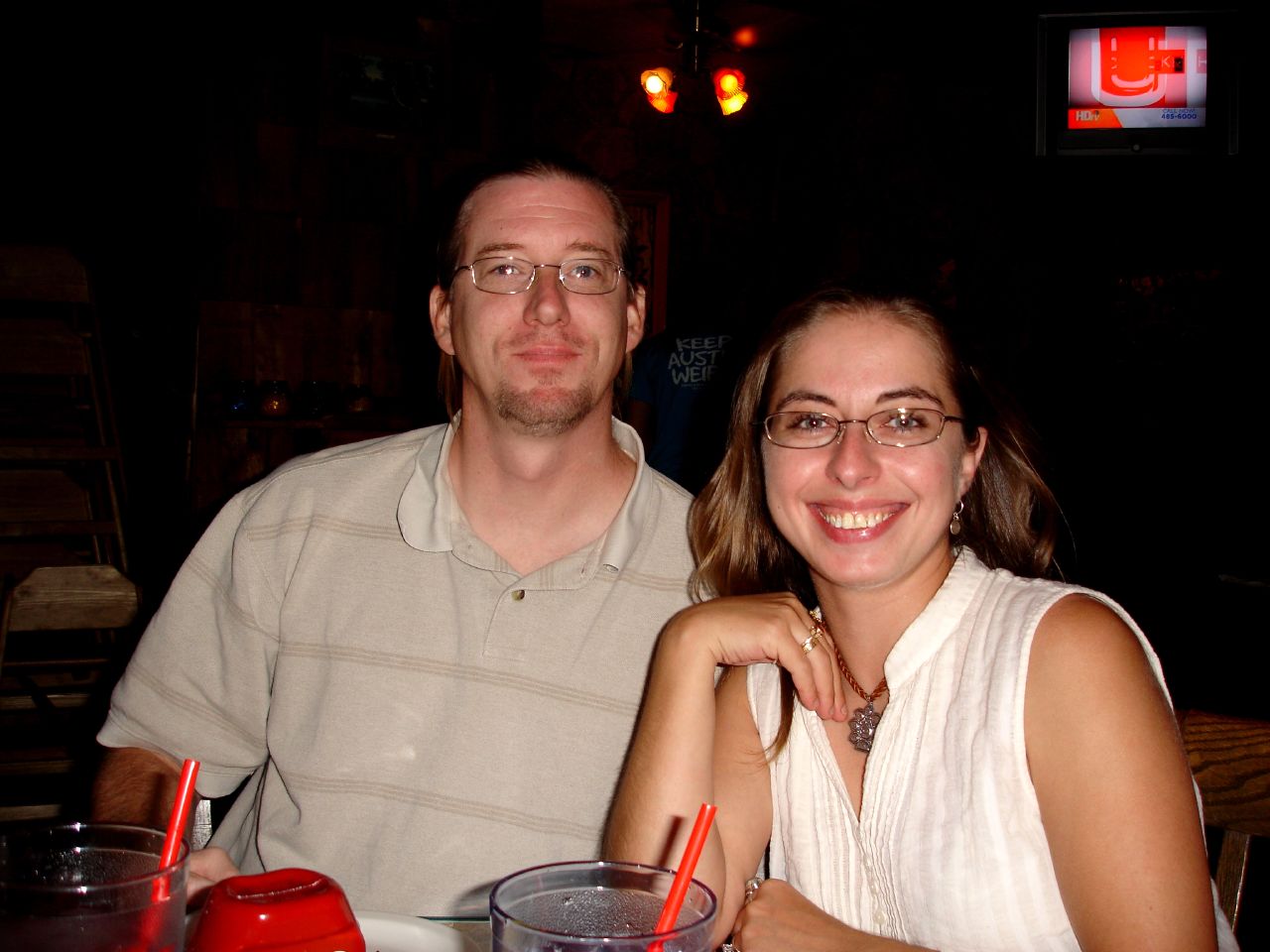 two people sitting at a table with drinks