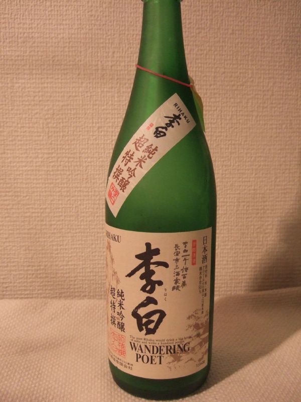 a bottle sitting on a white surface with writing on it