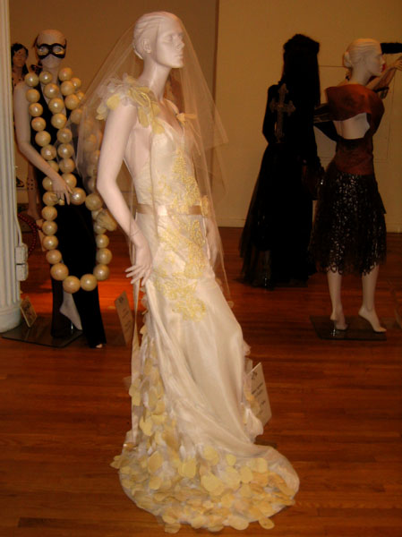 a mannequin dressed in a yellow wedding gown is shown on display