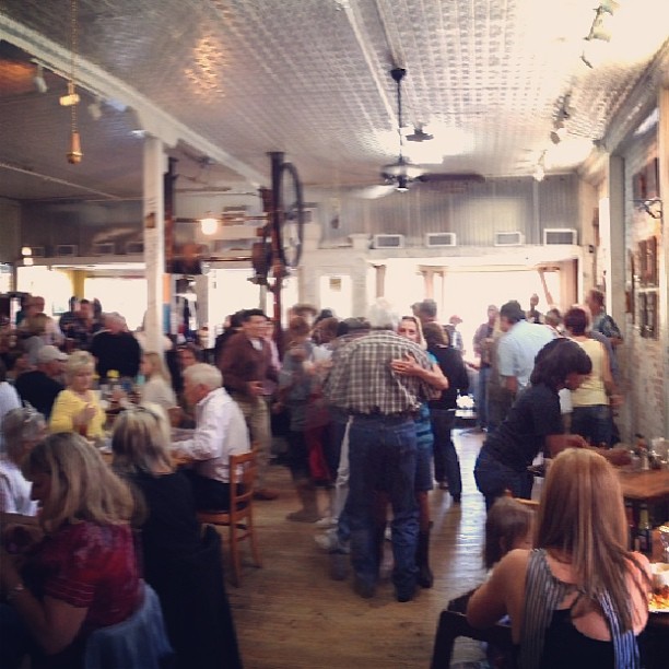 a very crowded room with many people eating