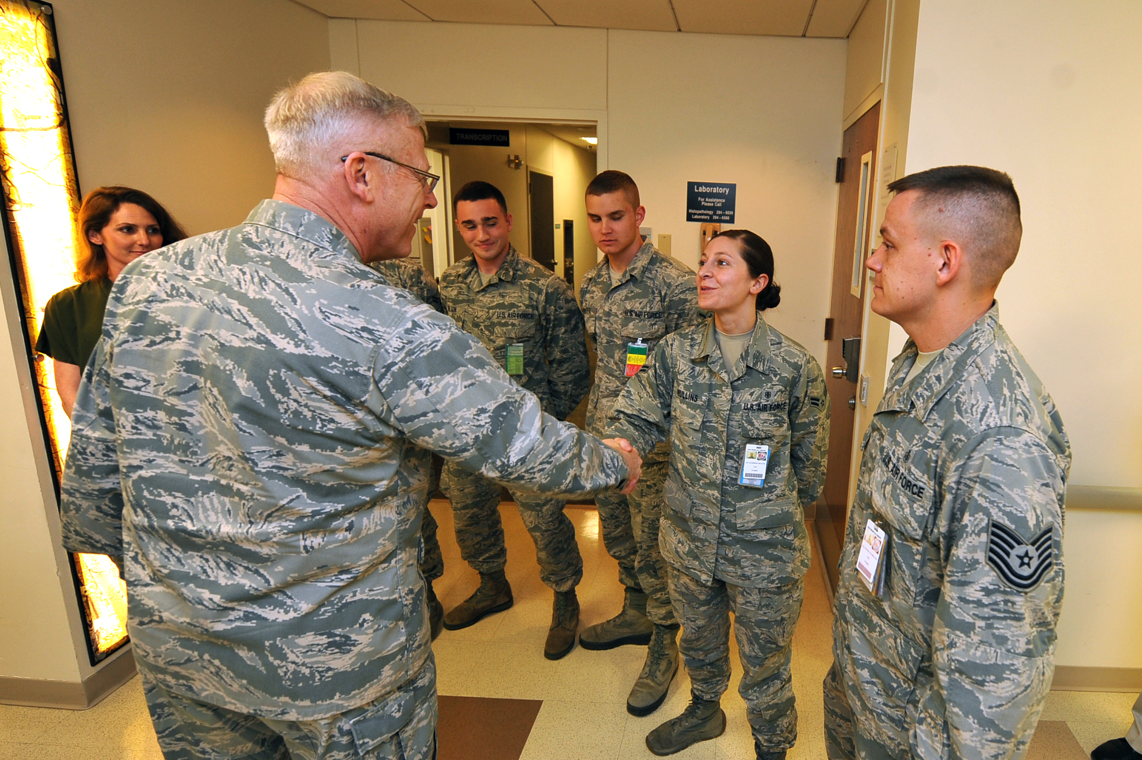 a couple of men shaking hands next to a woman