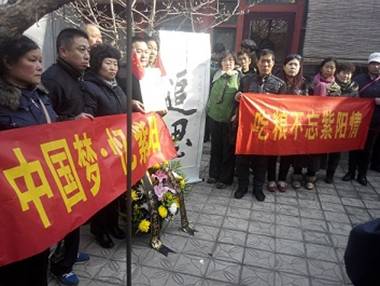 many people holding red and yellow signs in front of a building