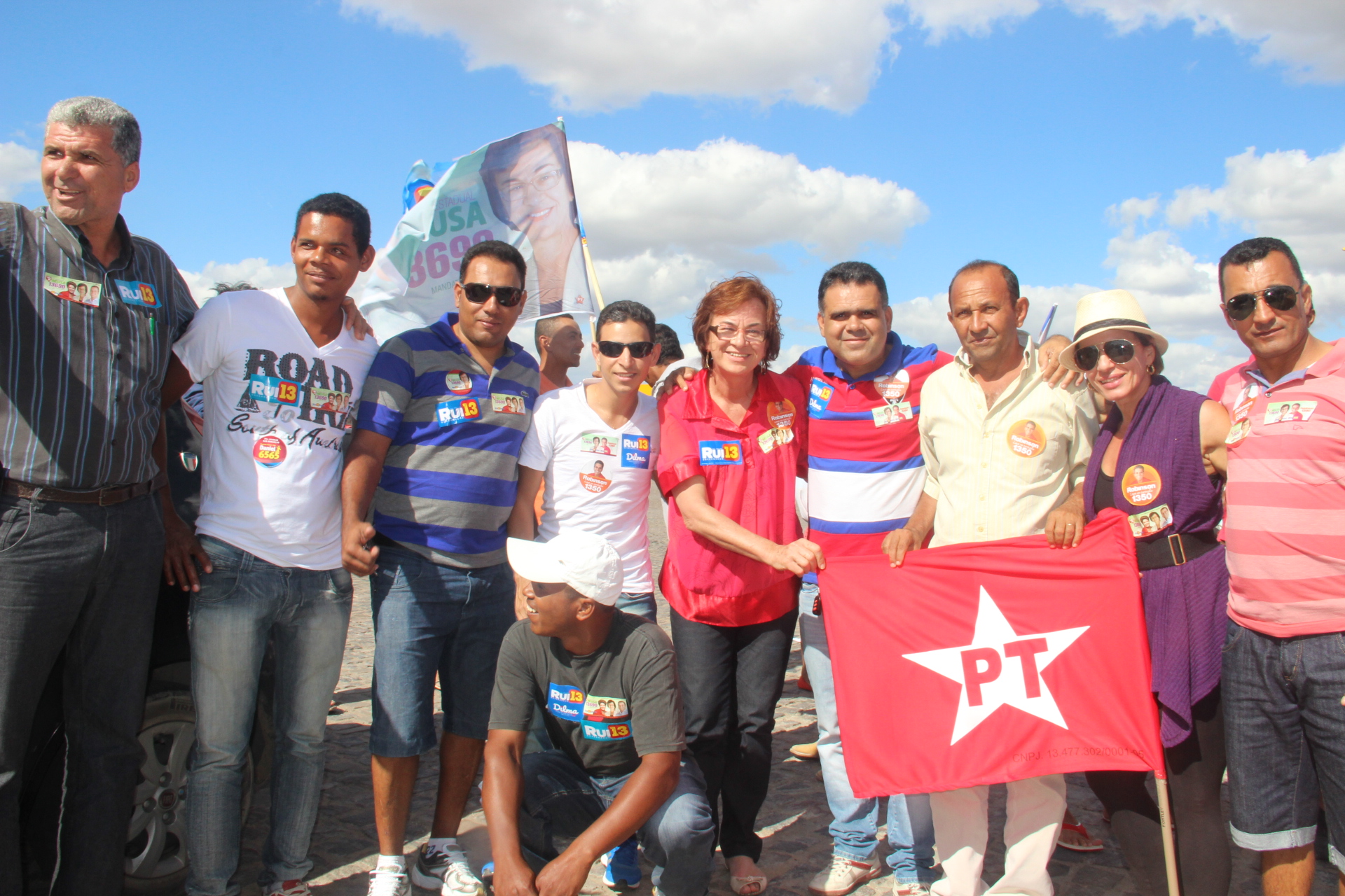 group of people in striped shirts holding up a small red star