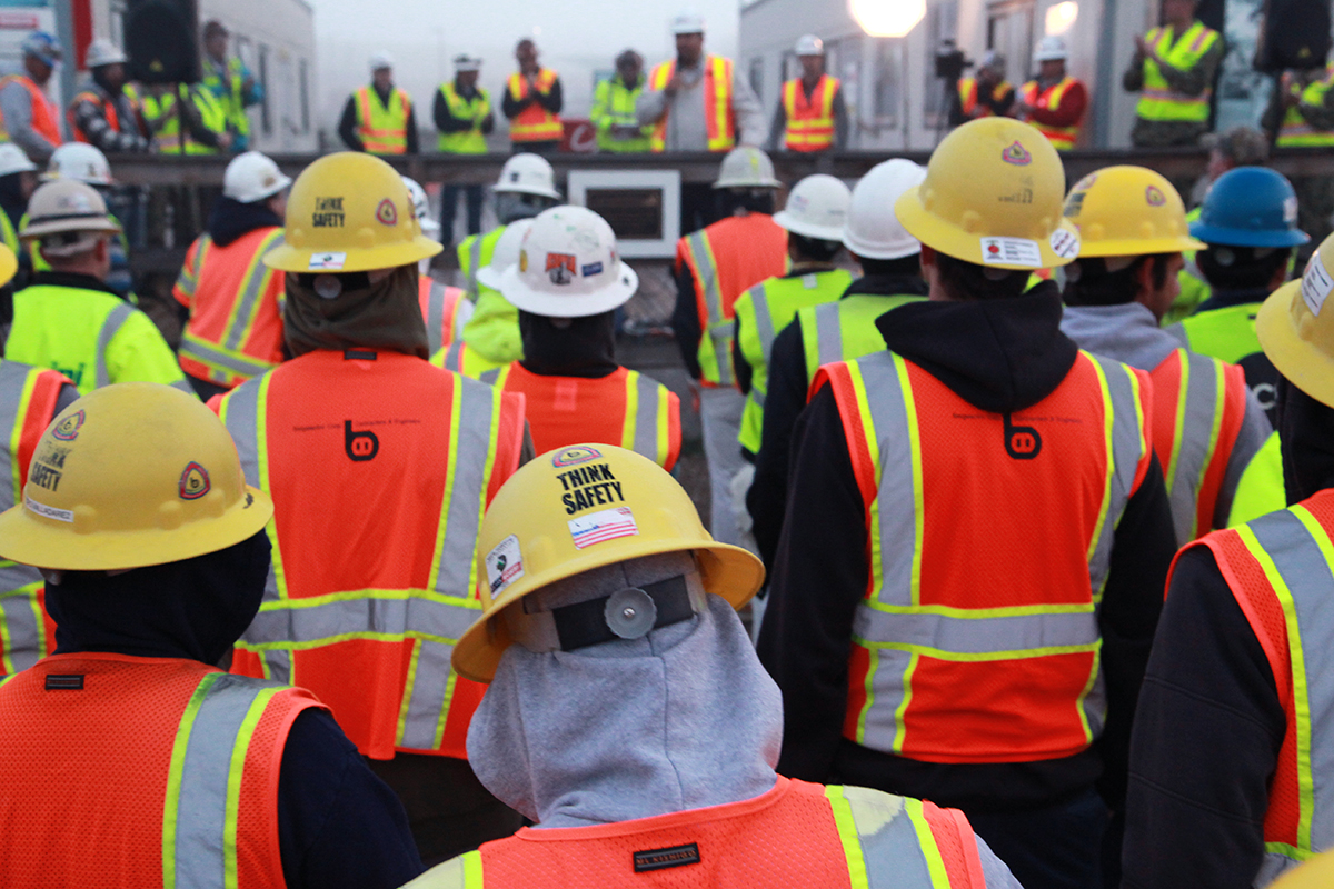 a large group of construction workers in their safety jackets