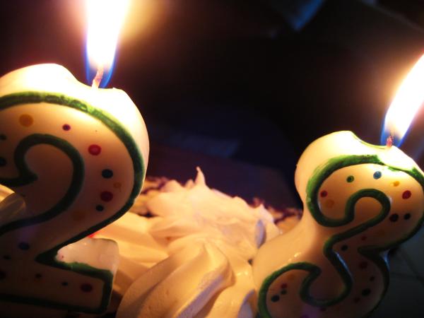 a couple of birthday candles sitting in front of cake