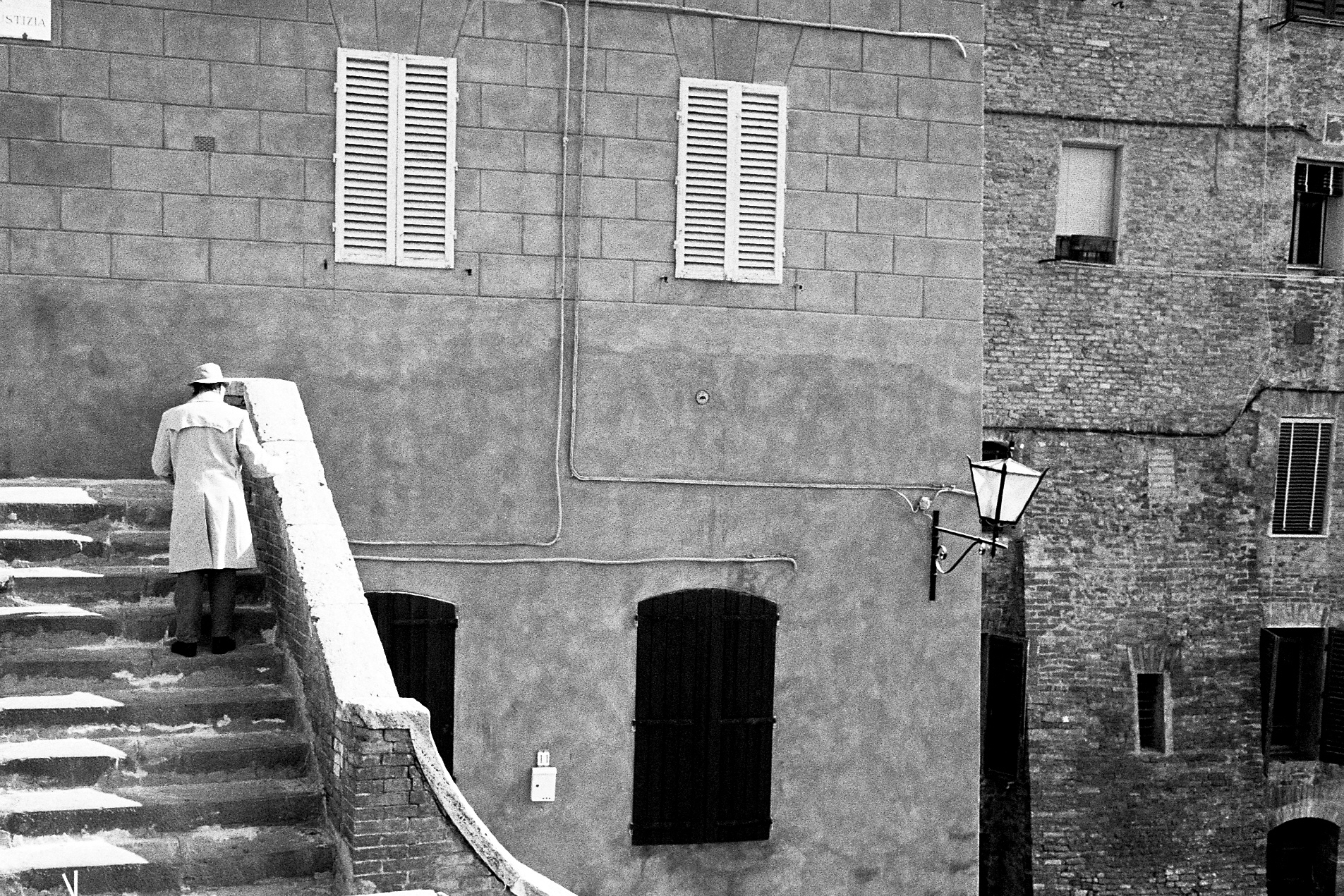 the staircase in front of an old building with two balconies and a white umbrella