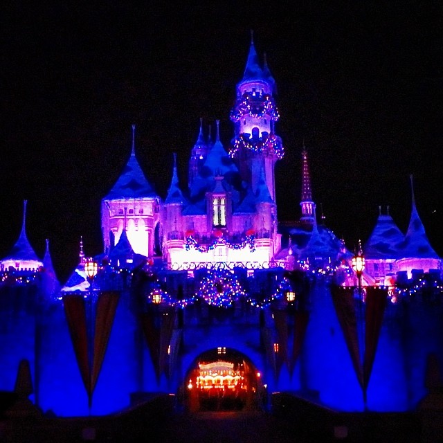 a night view of a castle at disneyland