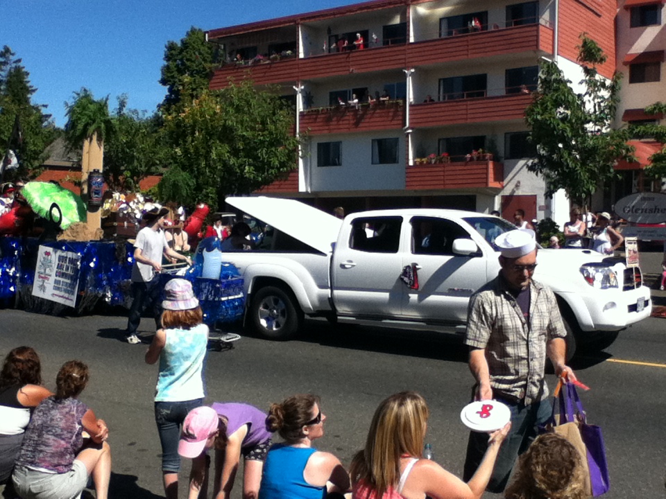 people watching a parade with a parade float in the background