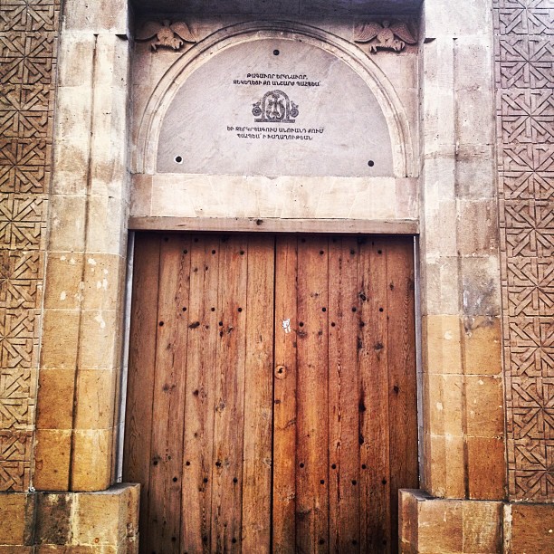 the door to a church with ornate carved and wood doors