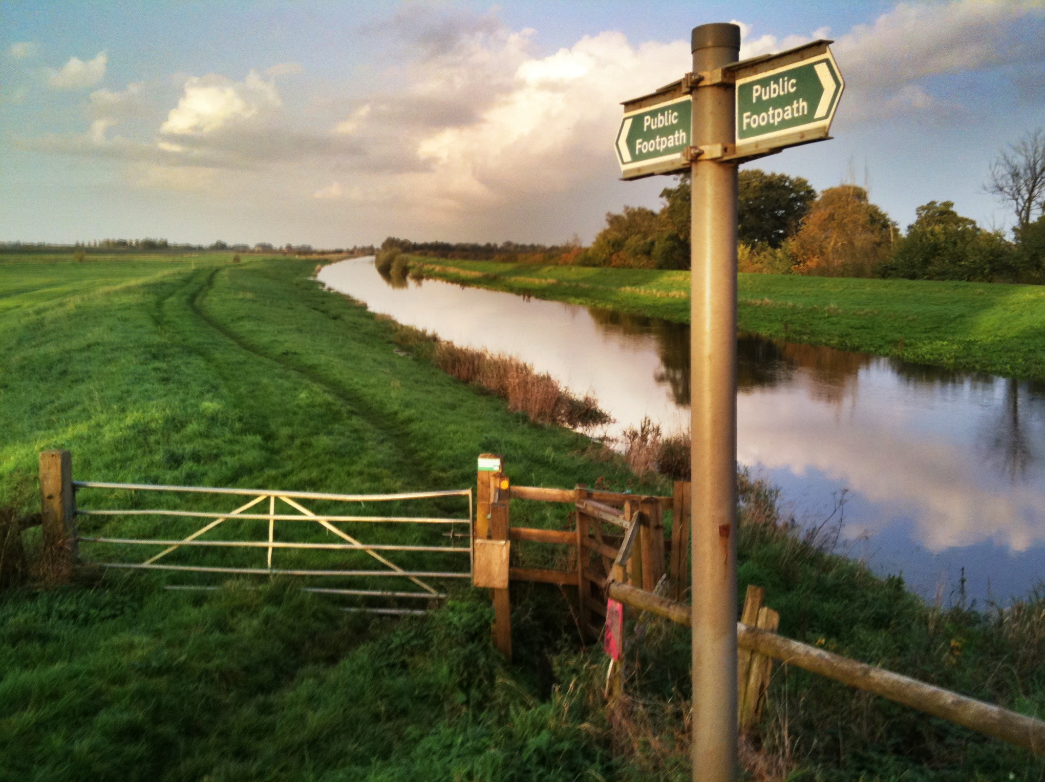 the view of a canal in a green country