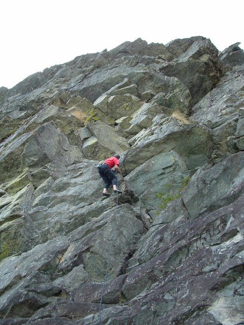 an adult is climbing up rocks by himself
