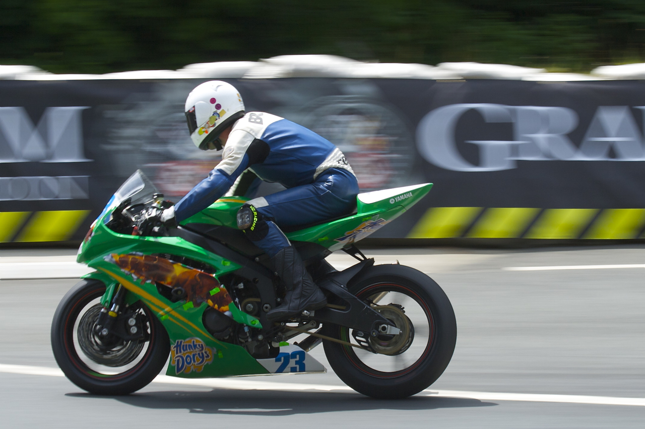 a man riding on the back of a motorcycle down a race track