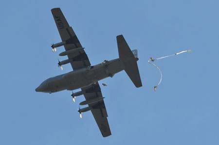 a fighter plane flying above and dropping on a string