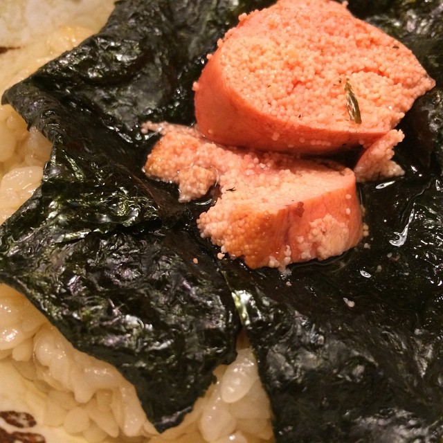 meat on a piece of spinach next to rice