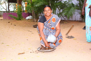a women who is sitting down holding a pot