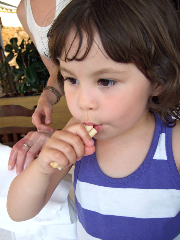 a  eating soing with her mother's hand