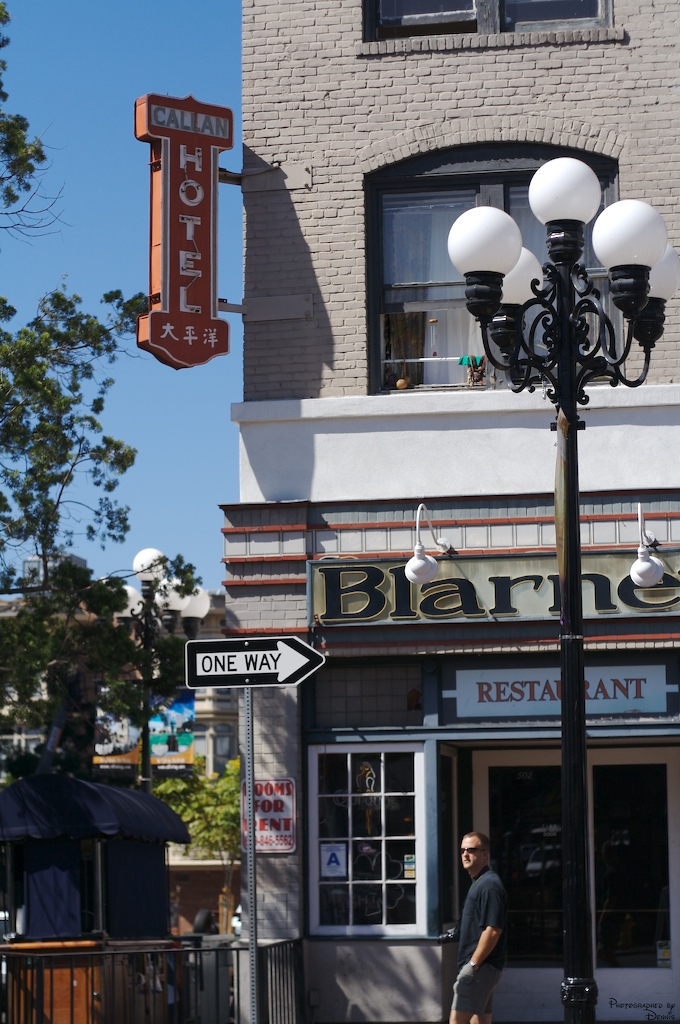 a man stands on the corner near a restaurant