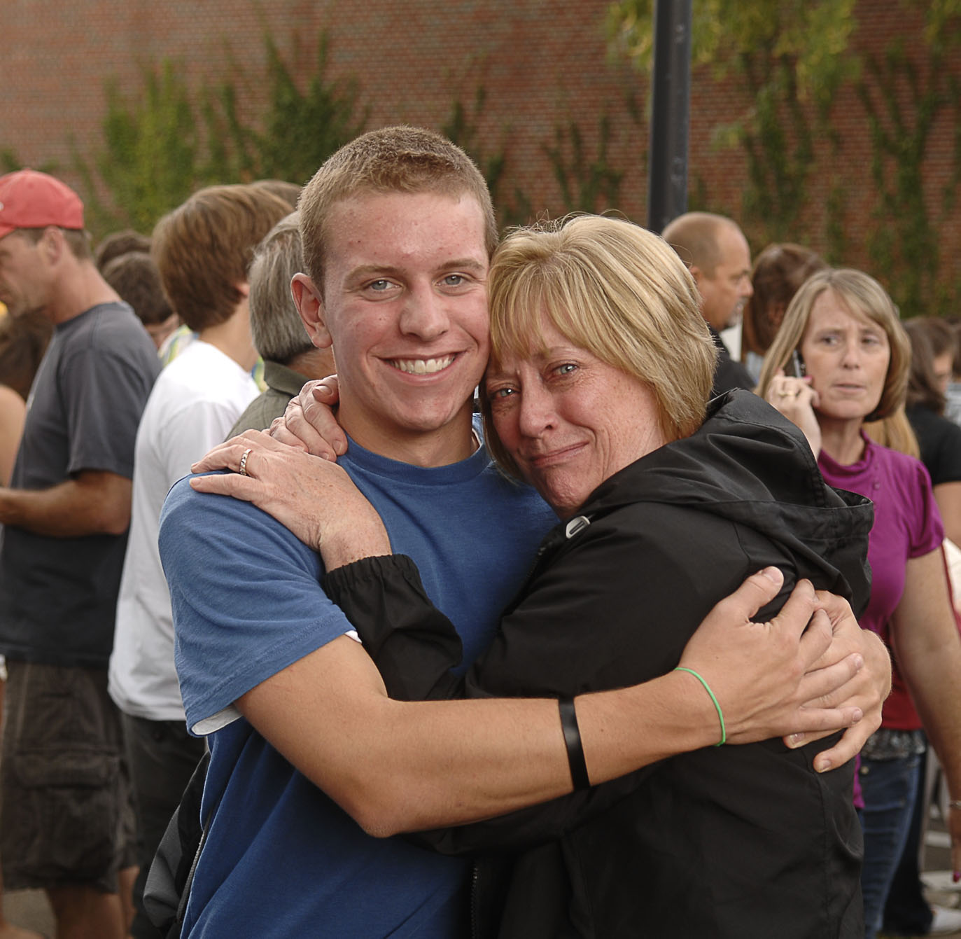 two people hug and smile in front of crowd
