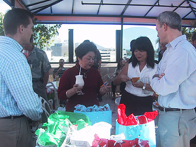 four people gathered around a table with plastic bag sandwiches