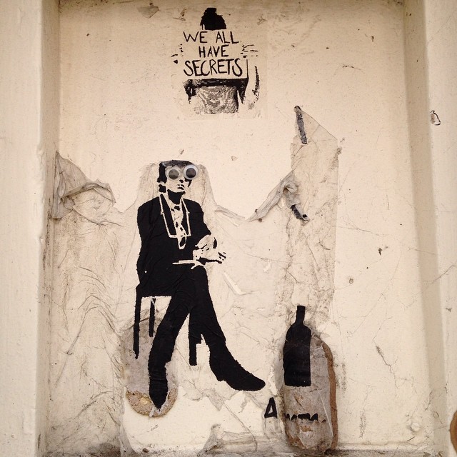 a mural on the side of a wall depicting a person on a chair next to a bottle