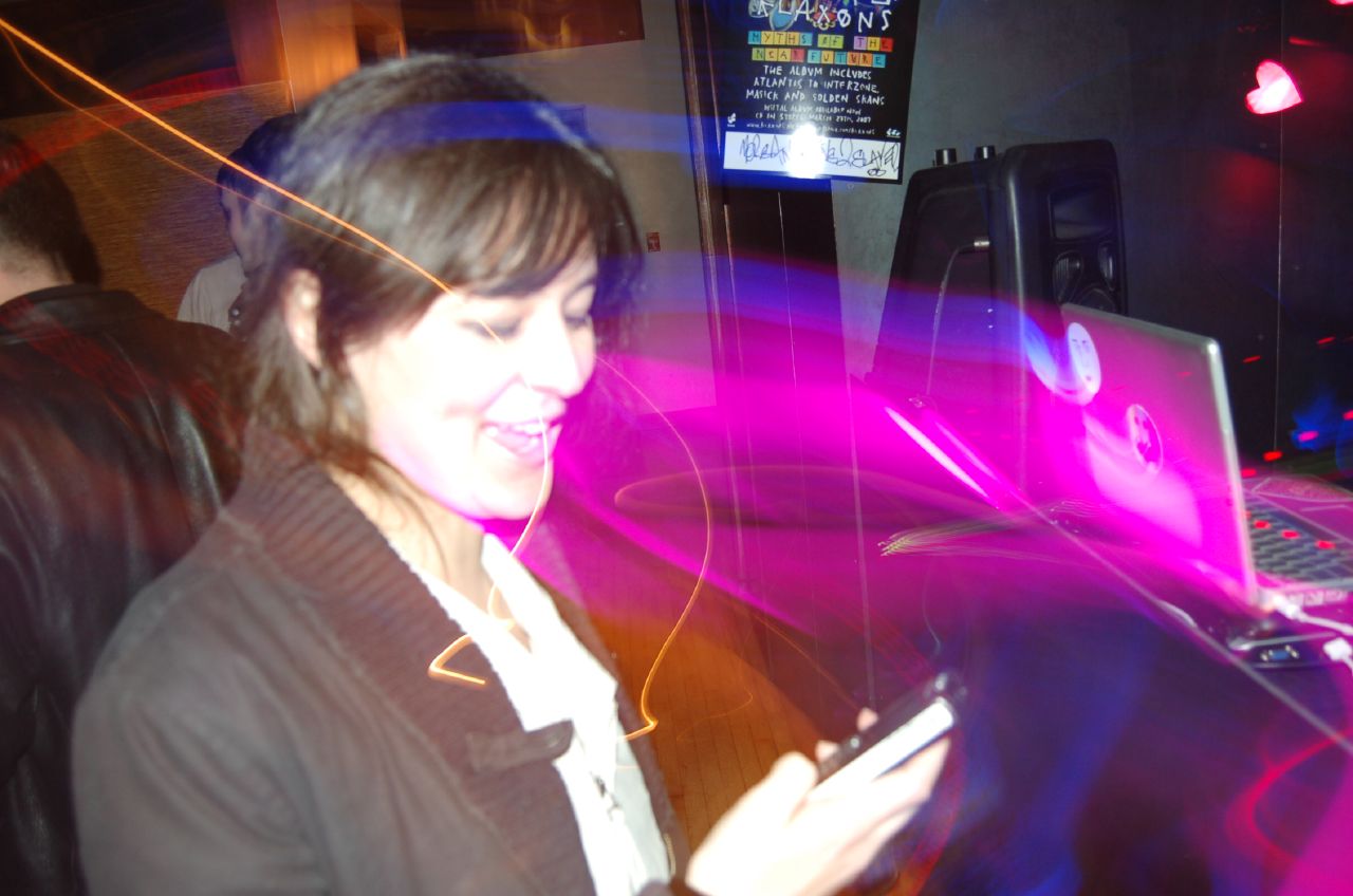 a woman is texting on her cellphone while sitting at a table