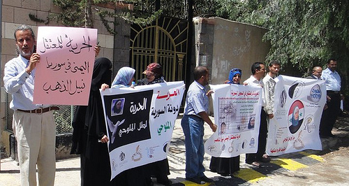 people holding up signs with arabic writing on them