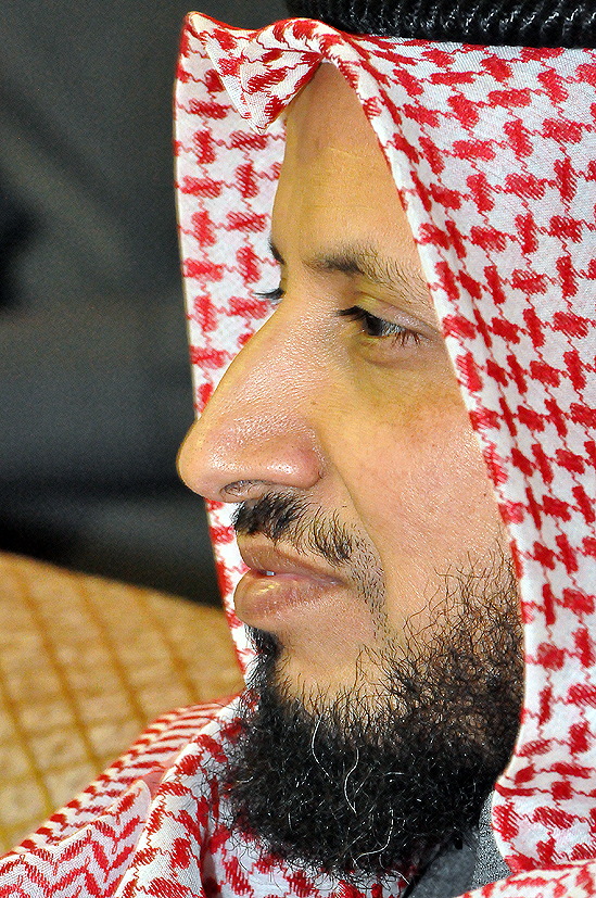 man with beard wearing traditional headdress looking at soing