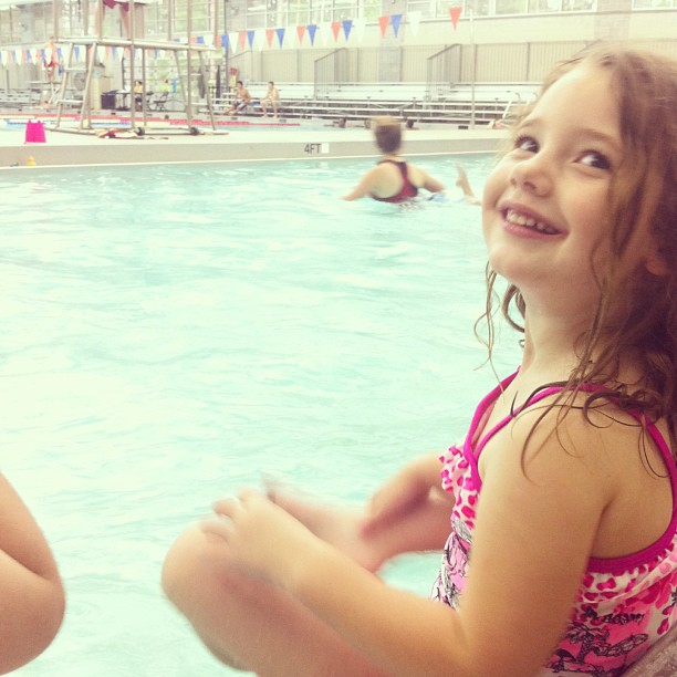 two little girls in a swimming pool with no swimming suits