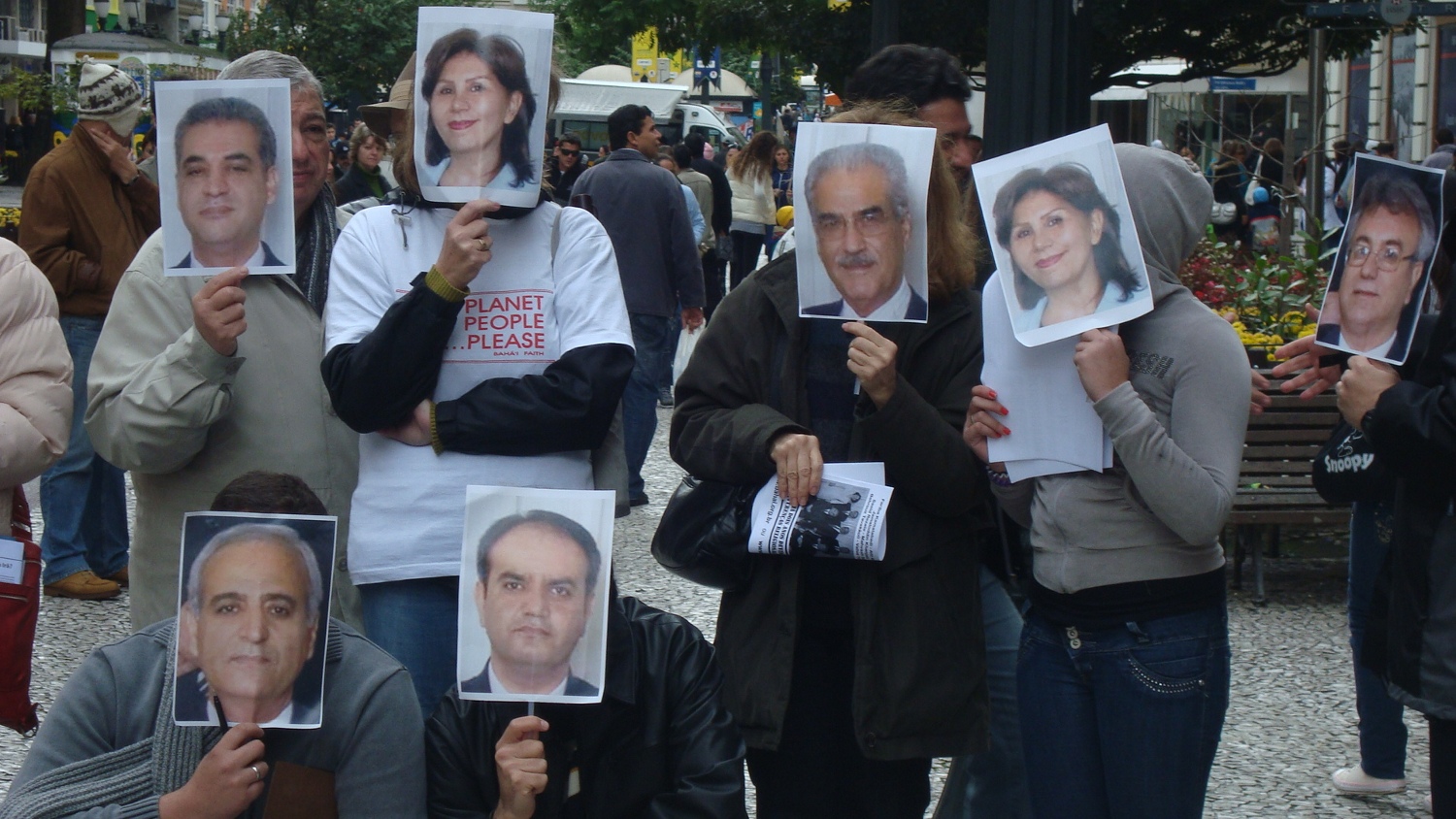 a group of people holding up signs and posing for the camera