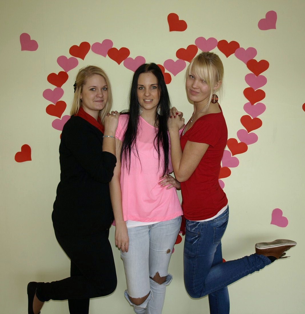 three women wearing pink and black posing for a po